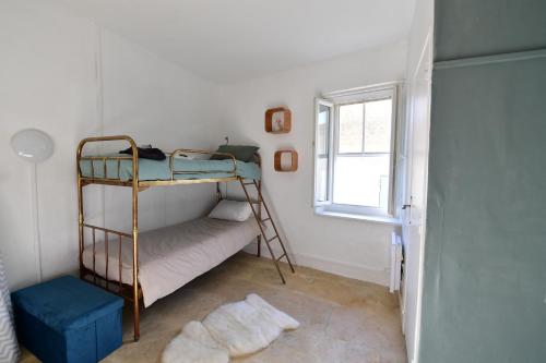 a bedroom with a bunk bed and a window at Maison de village Sud de France in Marsillargues