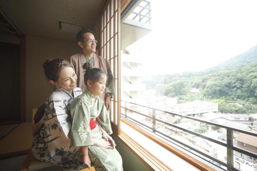 a man and two children looking out of a window at Kotohira Onsen Kotosankaku in Kotohira