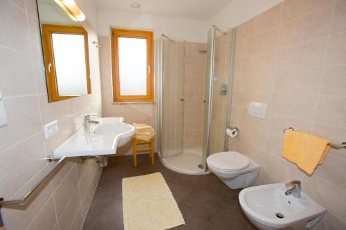 a bathroom with a sink and a shower and a toilet at Schötzerhof in Meltina