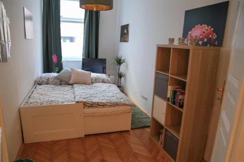 グラーツにあるlovely apartment in the heart of Grazの小さなベッドルーム(ベッド1台、本棚付)