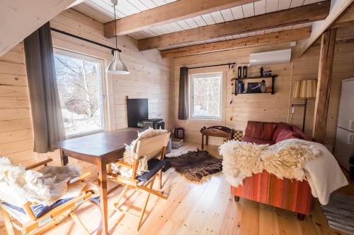 a living room with a table and a couch at Stuga Petruslogen in Malung