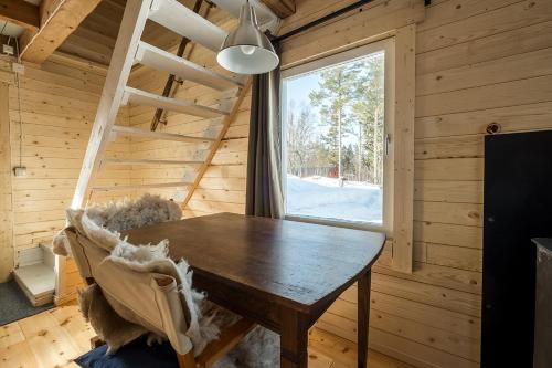 comedor de madera con mesa y ventana en Stuga Petruslogen, en Malung