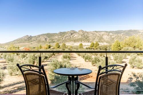a table and chairs on a balcony with a view of the desert at Hotel Rural Los Nogales in Pozo Alcón