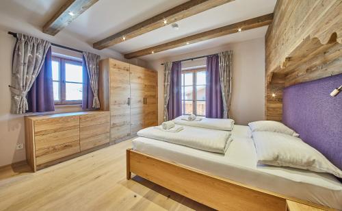a bedroom with a large bed and a purple wall at Chalet Guter Hirte in Saalbach Hinterglemm