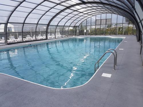 una gran piscina en un edificio con techo de cristal en Camping Le Walric, en Saint-Valery-sur-Somme