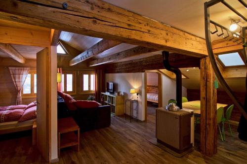 um quarto com uma cama e uma sala de estar em Appartement sous les combles - Chalet La Biolle - Vercorin em Vercorin