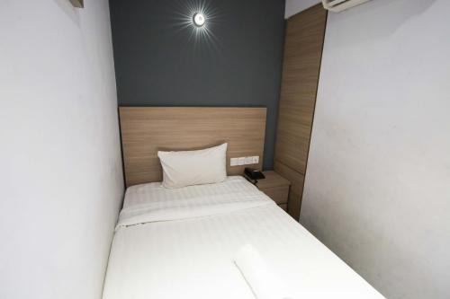 a small bed in a small room with at Hotel 99 Kota Kemuning in Shah Alam