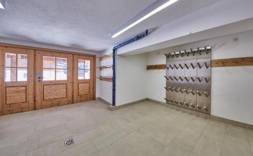 a large room with wooden doors and tile floors at Chalet Guter Hirte in Saalbach Hinterglemm