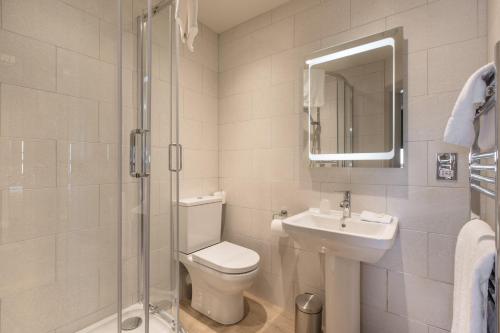 a bathroom with a toilet and a sink and a shower at The George Hotel in Castletown