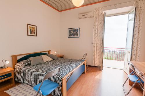 SantʼAlfioにあるAl Villino Sunshine in villa con piscina ed idromassaggioのベッドルーム1室(青い椅子、窓付)