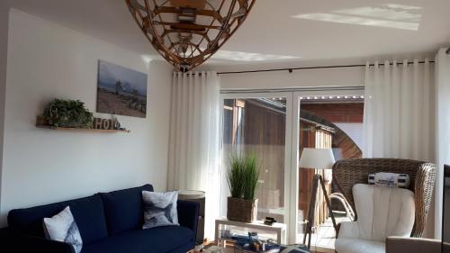 ein Wohnzimmer mit einem blauen Sofa und einem Fenster in der Unterkunft Ankerplatz in Weener
