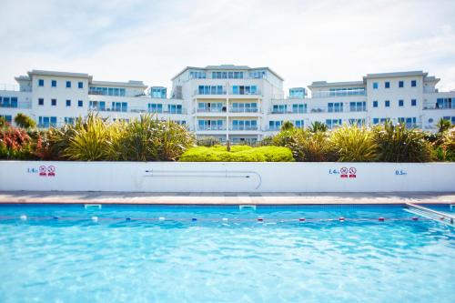 a swimming pool in front of a large building at St Moritz Hotel in Polzeath
