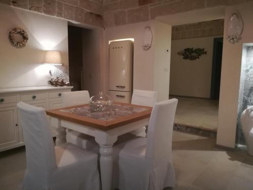 a kitchen with a wooden table and white chairs at Casa Carlotta in Monopoli
