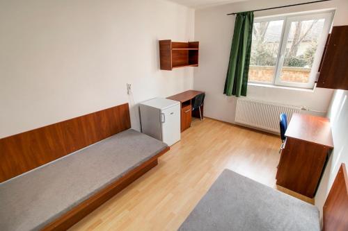 Zimmer mit einem Bett, einem Schreibtisch und einem Fenster in der Unterkunft Óbudai Diákszálló in Budapest