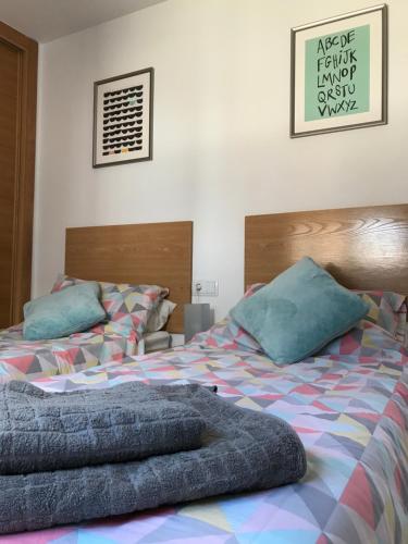 una camera con 2 letti con cuscini blu di Lucella Apt a Murcia