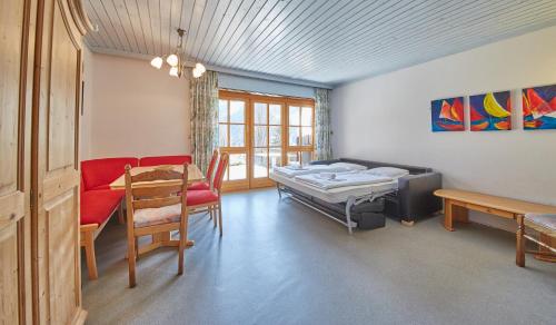 a room with a bed and a couch and a table at Appartement Bernkogel in Saalbach Hinterglemm