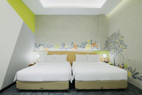 A bed or beds in a room at Zest Sukajadi Bandung by Swiss-Belhotel International