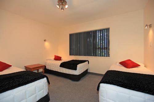 a hotel room with two beds and a window at Kapiti Lindale Motel and Conference Centre in Paraparaumu