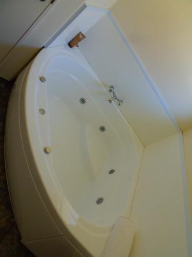 a bathroom with a white bath tub in a room at Kapiti Lindale Motel and Conference Centre in Paraparaumu