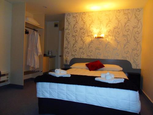 a bedroom with a bed with towels on it at Kapiti Lindale Motel and Conference Centre in Paraparaumu