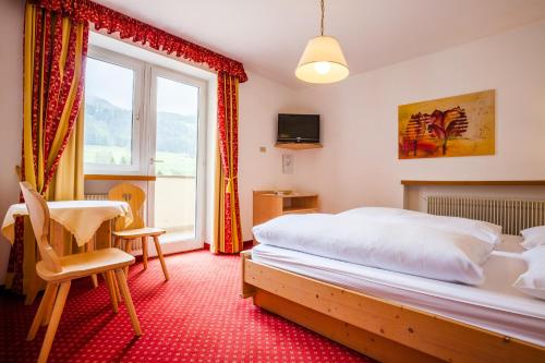 a bedroom with a bed and a desk and a window at Hotel Willy in Sesto