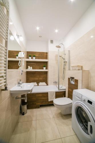 a bathroom with a sink toilet and a washing machine at Apartamenty Roztocze in Zwierzyniec