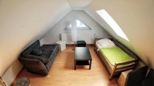 a attic room with a bed and a couch at Strandvilla Thiessow in Thiessow