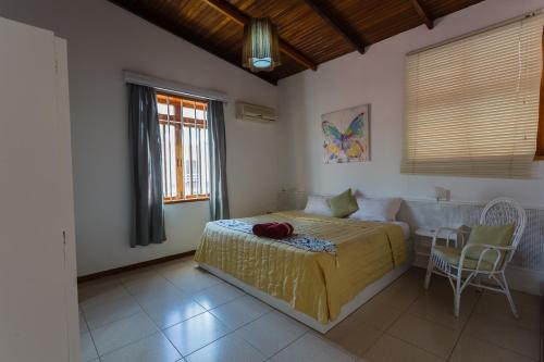 een slaapkamer met een bed, een bank en een tafel bij Residence Villas Mont Choisy in Mont Choisy