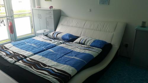 a bed with a blue and white comforter in a bedroom at 2-Zi-WHG Messenah in Hannover