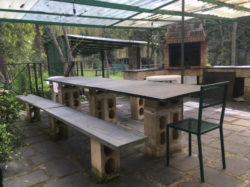 a picnic table with a chair and a bench at Hotel Rural Camino Medulas in Ponferrada
