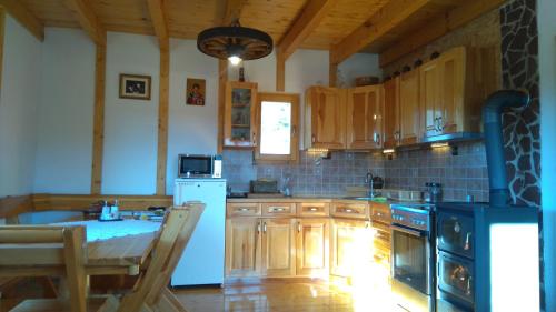 a kitchen with wooden cabinets and a stove top oven at Eco house in Žabljak