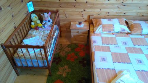 a bedroom with two twin beds and a crib at Eco house in Žabljak
