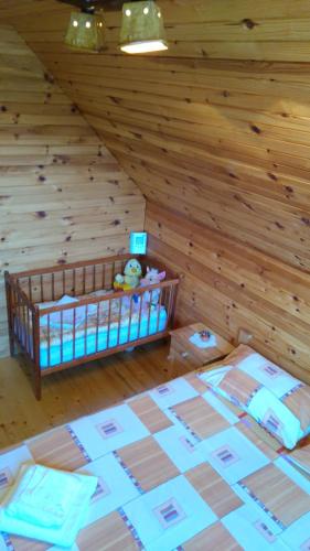 a room with a crib in a log cabin at Eco house in Žabljak