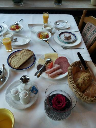 a white table topped with plates and bowls of food at Bertricher Hof Hotel Garni in Bad Bertrich