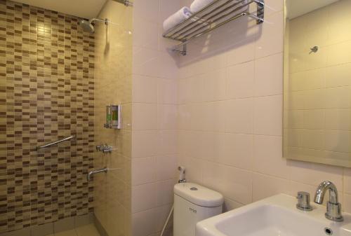 La salle de bains est pourvue de toilettes, d'un lavabo et d'une douche. dans l'établissement Amaris Hotel Tendean, à Jakarta