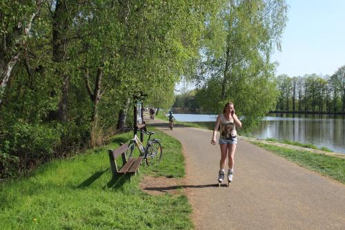 a woman walking down a path next to a lake at Apartment Promenada in Poděbrady