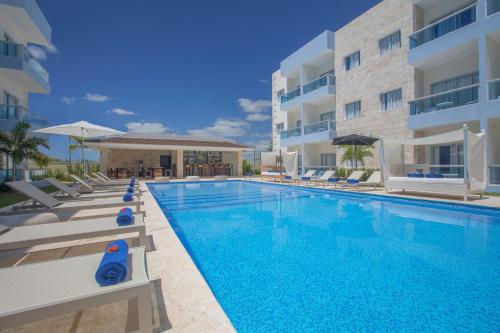 a swimming pool in front of a building at Hotel whala!urban punta cana in Punta Cana