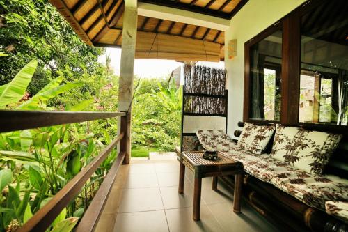a porch with a couch and a table at Bali Dream House in Amed
