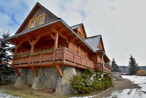 a large wooden house with a balcony on top at Penzión Schweintaal in Braväcovo