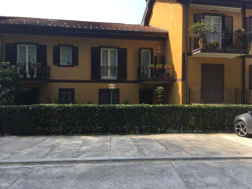 a house with a hedge in front of a building at Suite Ananda in Verbania