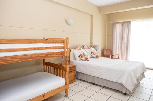 1 dormitorio con 2 literas y ventana en Seabrook 204 Margate RSA, en Margate