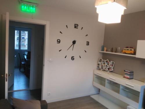 un reloj grande en la pared de una habitación en Apartamento Turístico Marcelo Celayeta AT Cerca del Centro, en Pamplona