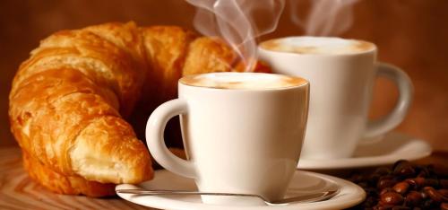 two cups of coffee and croissants on a table at Gli Agrumi Rooms in Trapani