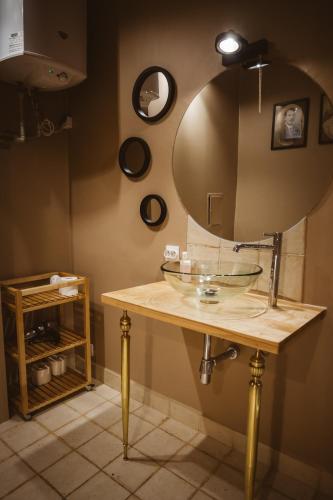 a bathroom with a glass sink and a mirror at Apartament Koci Łeb in Toruń