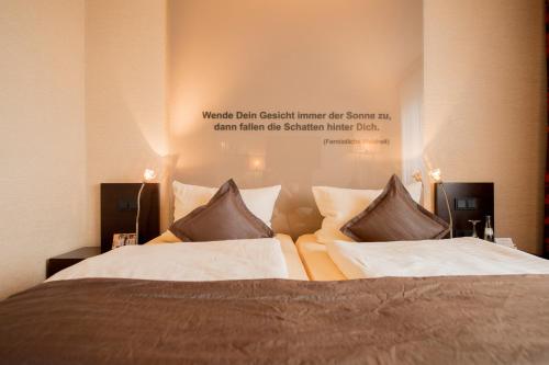 a bedroom with two beds with a sign on the wall at Atrium Hotel Mainz in Mainz