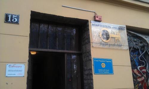a black door with a sign on the side of a building at Aparthotel NA DOBU in Lviv
