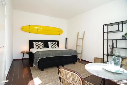 a bedroom with a bed with a surfboard on the wall at Hotel Zand in Zandvoort