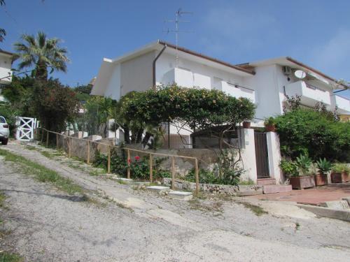 uma casa branca com uma cerca à frente. em Villa Majata em Realmonte