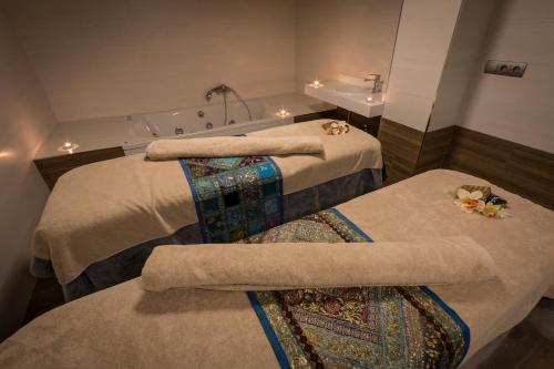 a hotel room with two beds and a bath tub at Catalonia Granada in Granada
