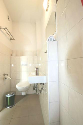 a white bathroom with a toilet and a sink at Penny Pension in Groß Sisbeck
